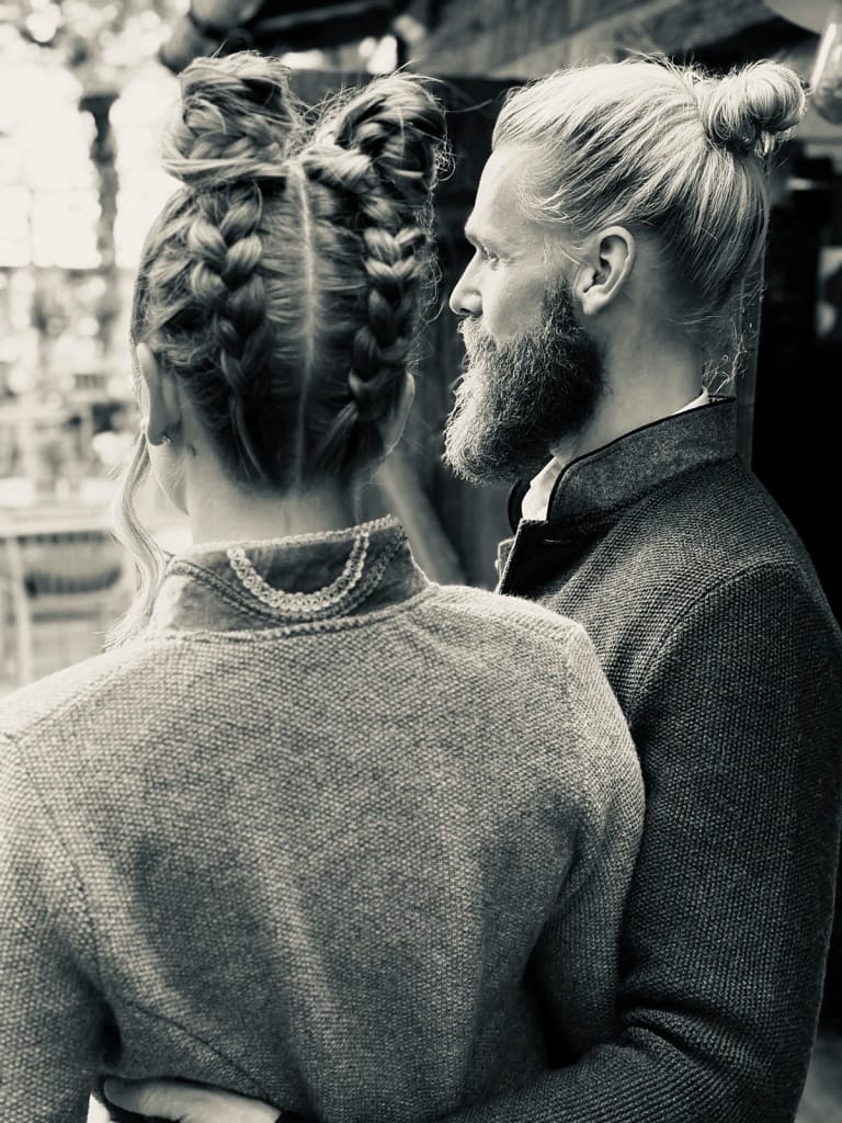 About 1 Gründer der Marke Wille & Style steht vor der urigen Hütte in Tracht und blickt fokussiert nach vorn.